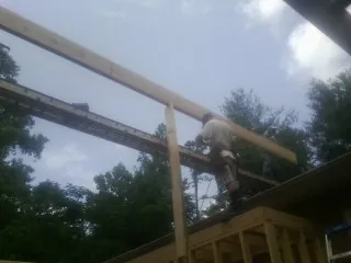 Carpenter setting a ridge beam over a new addition frame — Ice Dam Removal by Roofing Brothers in Hassell