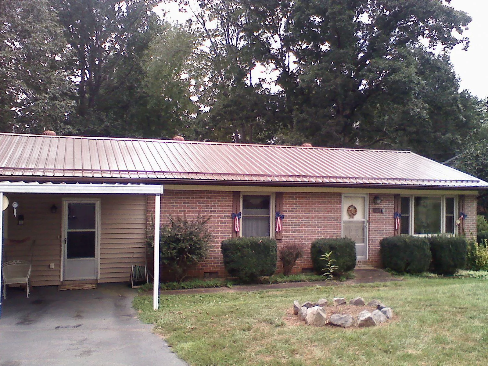 Bronze metal roof and carport on a brick ranch home — Roof Repair work by our crew in Hassell